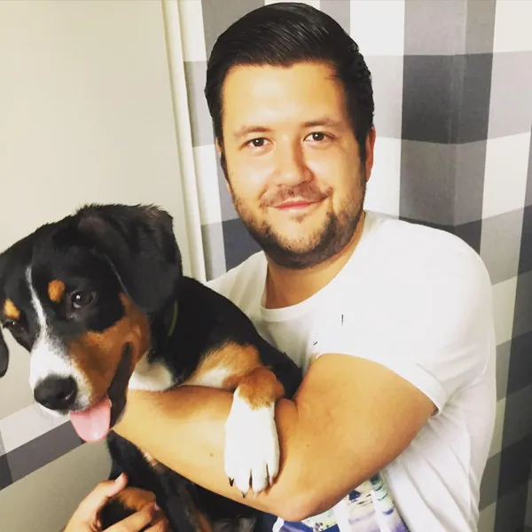 Benni 2015 im weißen T-Shirt mit seinem jungen Berner Sennenhund im Arm