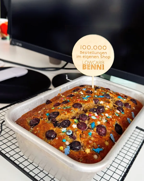 Kuchen mit Stecker 100.000 Bestellungen im eigenen Shop auf dem Schreibtisch im Büro, November 2025