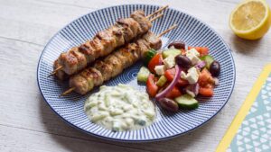 Souvlaki low carb: gegrillte griechische Fleischspieße mit Tzatziki und Bauernsalat auf einem Teller