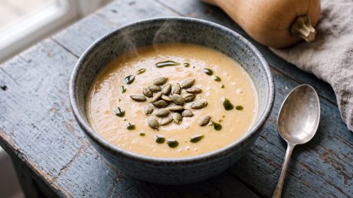 Kürbissuppe ohne Kokosmilch, cremig und low carb, in einer Schale mit gerösteten Kürbiskernen und Kürbiskernöl